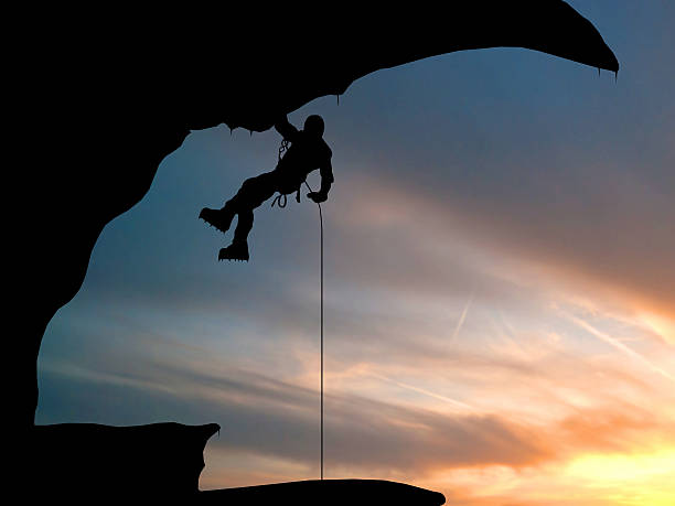 istock Mountain climber hanging on a rope. Background of sky 467755421