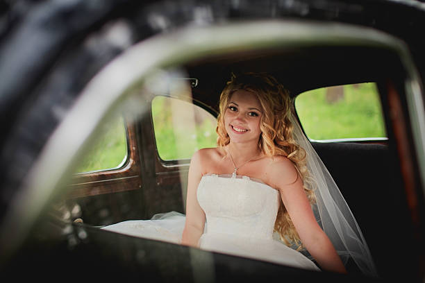 istock bride sitting in car and smile 467755587