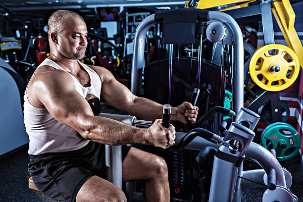 homem fazendo exercício com cama de máquina - human muscle men weights picking up - fotografias e filmes do acervo