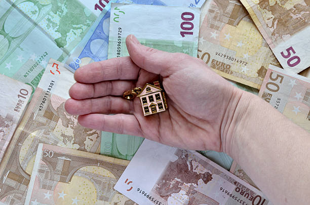 istock Money and a hand with a house 467759978