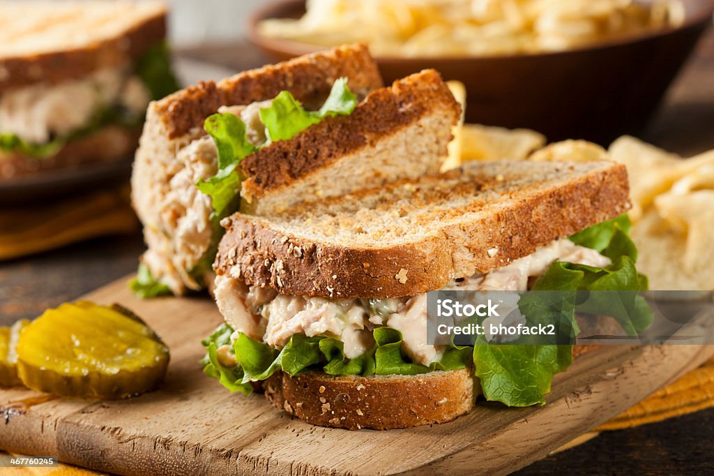 Tuna sandwich with lettuce on wheat toast Healthy Tuna Sandwich with Lettuce and a Side of Chips Tuna - Seafood Stock Photo