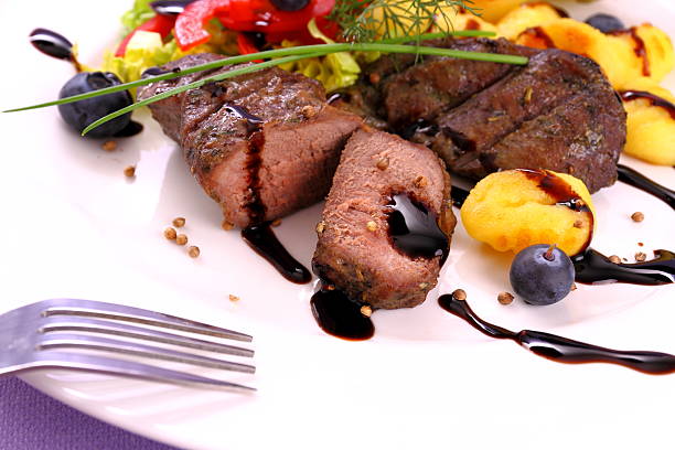 piece of rib eye steak on fork, shallow focus