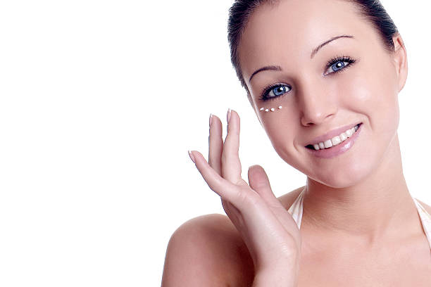 istock young woman applying creme on face 467763288