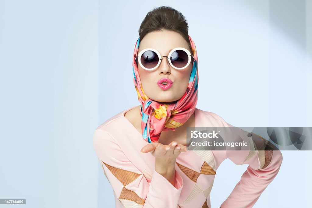 Sixties Style Girl Sixties style girl blowing a kiss. Retro fashion with silk scarf and sunglasses. Fashion Stock Photo