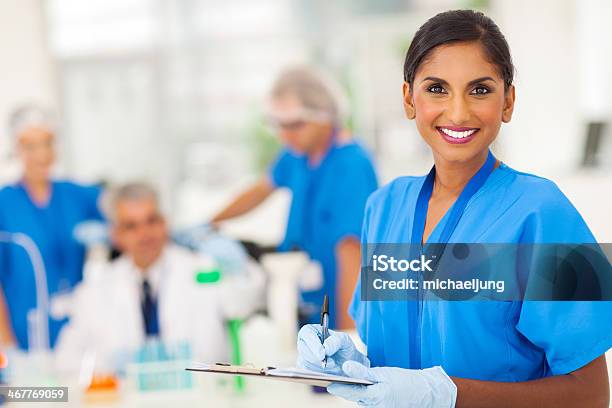 Young Medical Researcher Writing Report Stock Photo - Download Image Now - Doctor, Indian Ethnicity, Laboratory