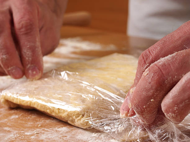 istock Wrap dough in clear film. Making short-cut puff pastry series. 467772498
