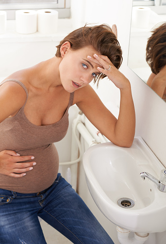 Shot of a pregnant woman holding her stomach in discomfort in the bathroomhttp://195.154.178.81/DATA/istock_collage/0/shoots/781782.jpg