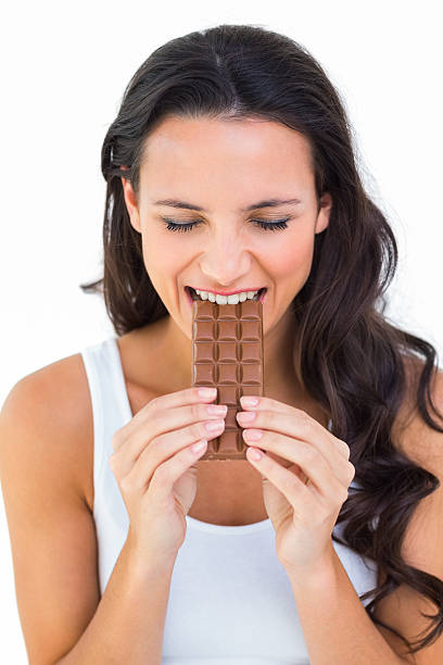 istock Pretty brunette eating bar of chocolate 467779002