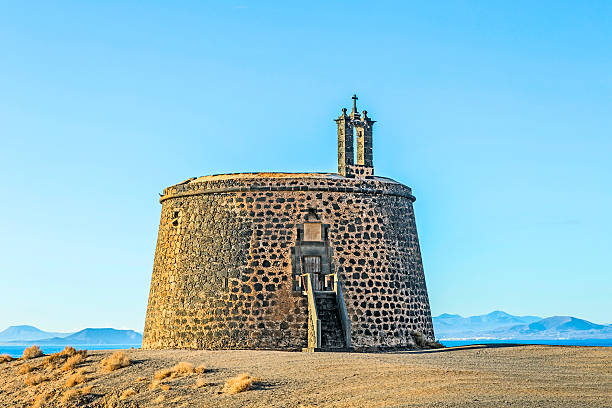 Small castle Castillo de las Coloradas on cliff in Playa Blanca, Lanzarote, Canary Islands, Spain