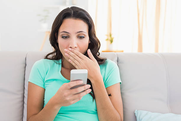 istock Shocked brunette texting on the phone 467782366
