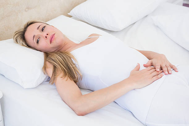 istock Grimacing woman suffering with stomach pain 467787046