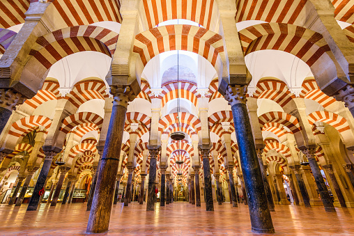 Cordoba, Spain - November 10, 2014: Hypostyle Hall of the Mosque-Cathedral. Though currently a catholic church, the building has a rich and complex history as both a Christian and Islamic holy site.