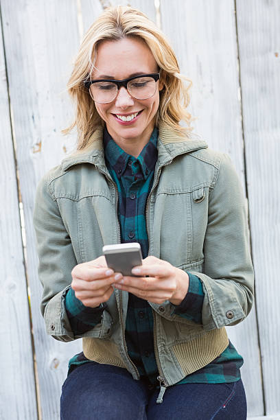 istock Happy blonde in glasses text messaging 467788714