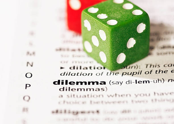 istock 'dilemma' highlighted in dictionary. Indecision? Throw the dice! 467789357
