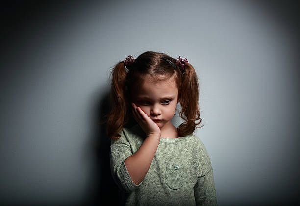 chica solo niño triste pensando sobre fondo oscuro. de problemas - displeased child abandoned child abuse fotografías e imágenes de stock