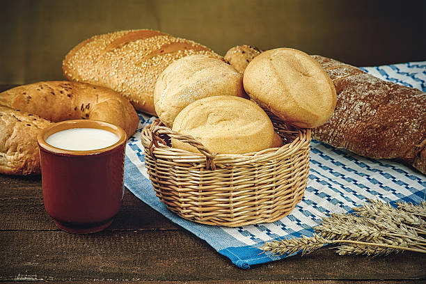 istock Wicker basket with bread products and milk on the tablecloth 467800048