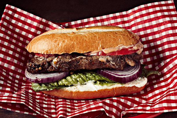 A delicious steak sandwich in a red basket done in the vintage style of Kodachrome 35 mm film.