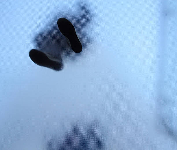 Stopy osoby stojącej na szkło przezroczyste – zdjęcie