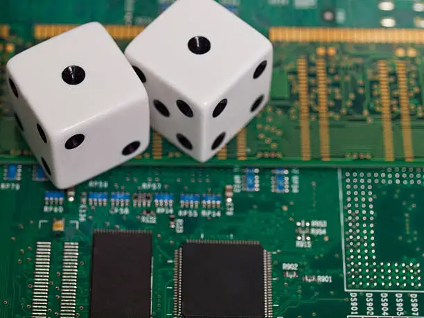 Pair of dice sitting on top of computer motherboard