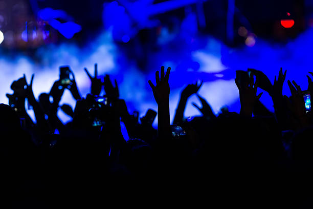 istock People taking photographs with touch smart phone during a music 467810490