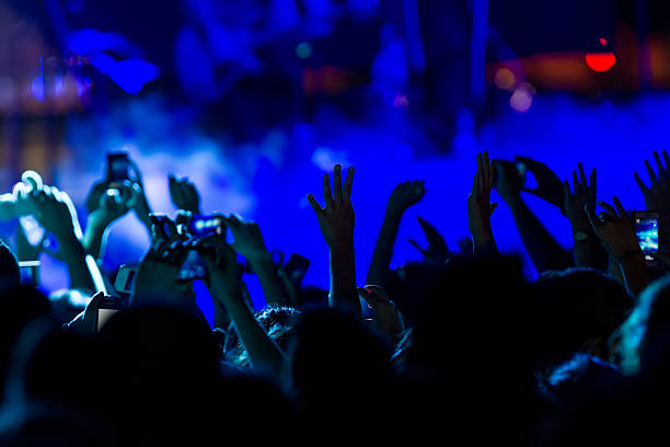 istock People taking photographs with touch smart phone during a music 467811178