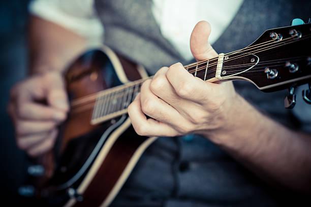 close up hands hipster man playing mandolin stock photo