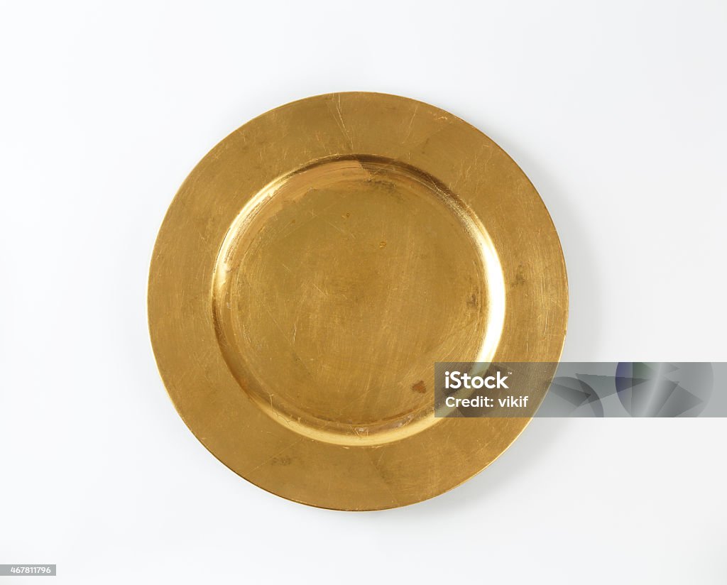 Round gold charger plate Round gold charger plate with wide rim Gold Colored Stock Photo