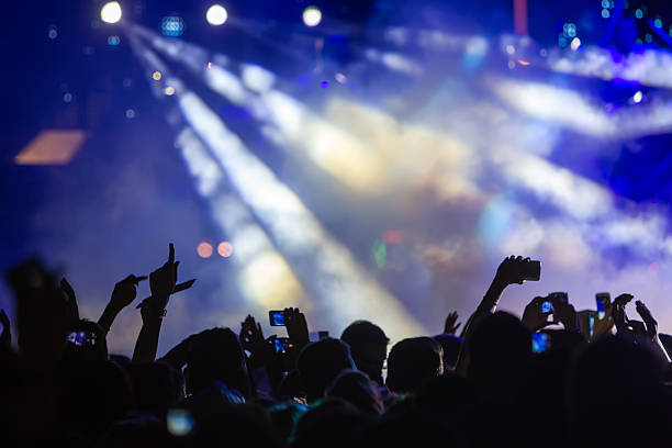 istock People taking photographs with touch smart phone during a music 467813902