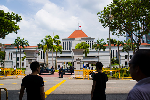 Singapore, Singapore - March 25, 2015: Thousands of people have joined the queue to pay their last respects to founding Prime Minister Lee Kuan Yew, lying in state at Parliament House. The state flag is at half-mast at the Parliament building. 