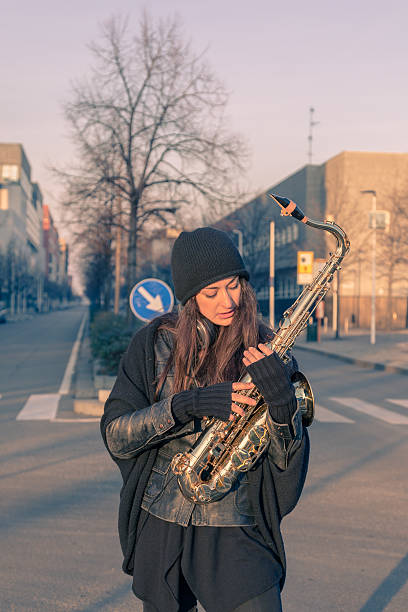 istock Beautiful young woman with her saxophone 467818146