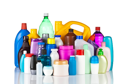 A large group of multicolored plastic bottles and containers standing on white backdrop. Bottles are of different sizes, shapes and colors and the bigger are in the background while the smaller are in the foreground.  The bottles are reflected in the foreground. Studio photo taken with DSRL Canon EOS 5D Mk II