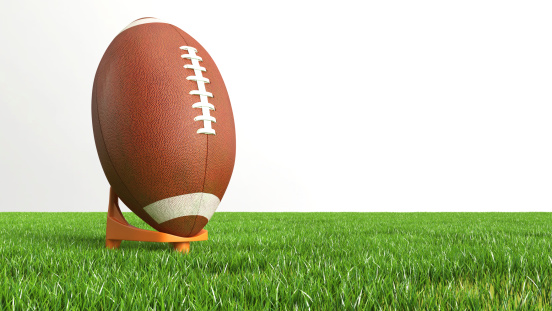 American Football on grass against a white background.