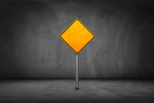 Street Sign: blank yellow road sign with street wall.