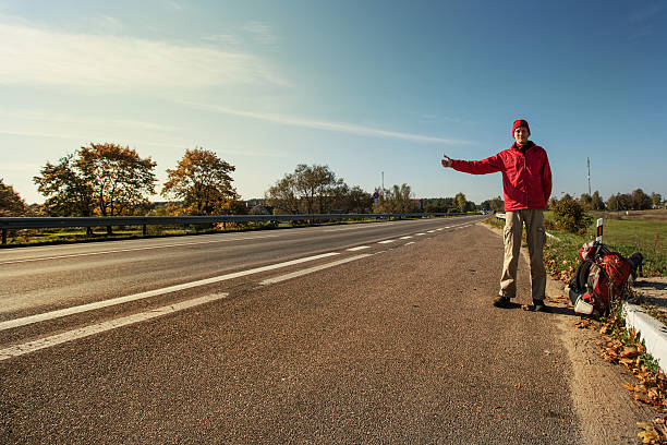 istock Young Man Hitchhiking on a Road 467822804