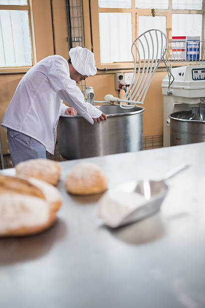 istock Baker preparing dough in industrial mixer 467824434