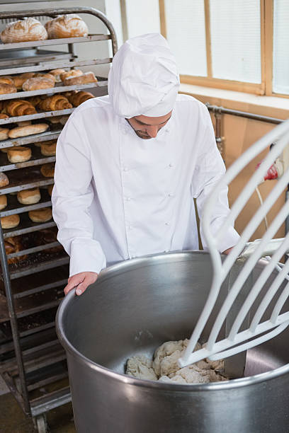 istock Baker preparing dough in industrial mixer 467824442