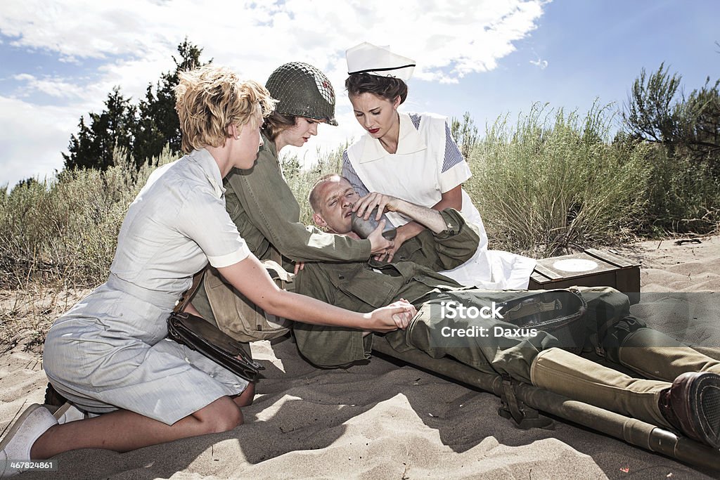 INFIRMIÈRES réconfortant un soldat de la Seconde guerre mondiale - Photo de Jeunes femmes libre de droits
