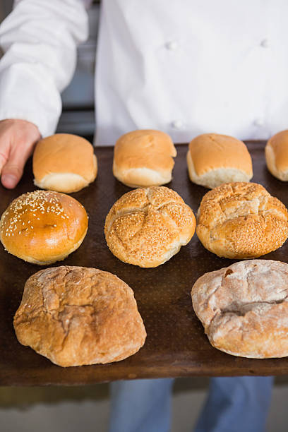 istock Close up of baker showing tray with bread 467825152