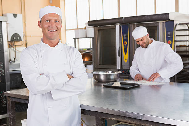 istock Smiling baker standing with arms crossed 467825372