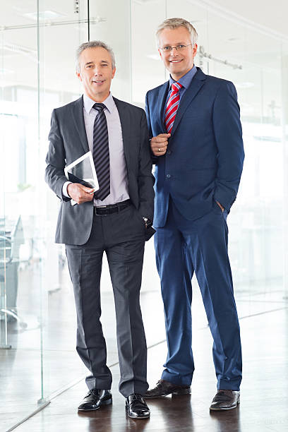 istock Two happy businessmen standing in office 467825760