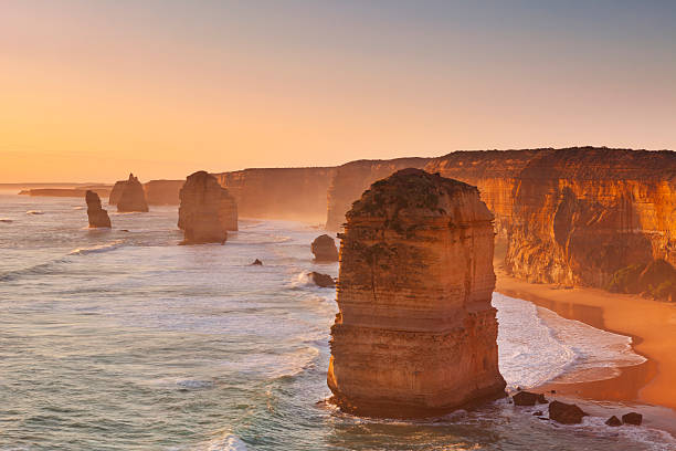 twelve apostles-bergkette auf die great ocean road, australien bei sonnenuntergang - australian culture landscape great ocean road beach stock-fotos und bilder