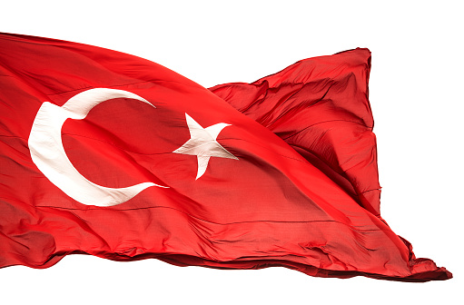 Turkish flag waving in the wind, isolated white background. High resolution picture of flag of Turkey.
