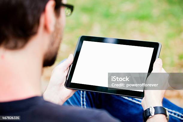 Photo libre de droit de Homme À Laide Dune Tablette banque d'images et plus d'images libres de droit de Prise de vue en extérieur - Prise de vue en extérieur, Vue de par-dessus l'épaule, Regarder par-dessus son épaule