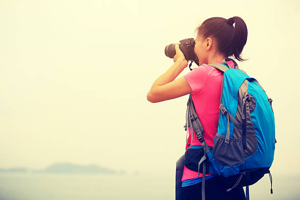 istock woman hiker taking photo with digital camera 467829268
