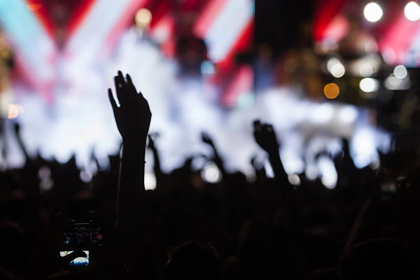 istock People taking photographs with touch smart phone during a music 467829524