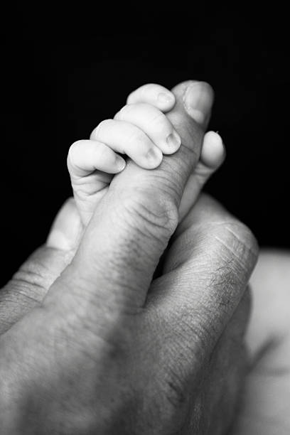 istock Newborn Hand Holding Dad's Finger 467831656