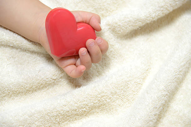istock Baby's hand with heart toy 467833106