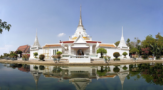 Thai Buddhist temple Wat Khan Lad is surrounded by a pond of water in Bangkok, Thailand