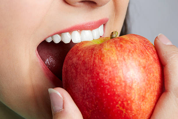 istock Unrecognizable woman eating red apple 467836958