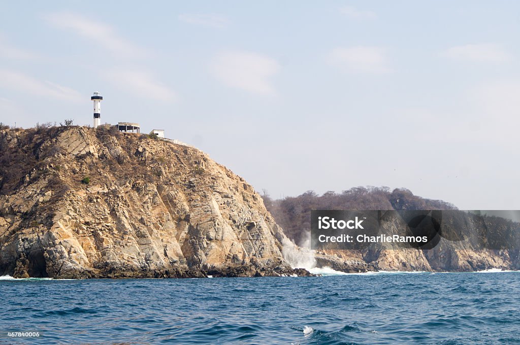 Bays of Huatulco. Lighthouse. Punta Santa Cruz Bahías de Huatulco, Oaxaca, Mexico. View from the ocean of Punta Santa Cruz. Lightouse and Blow Hole (Bufadora) Huatulco Stock Photo